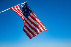 Picture of American flag on blue background for blog on Investing in American Workers.
